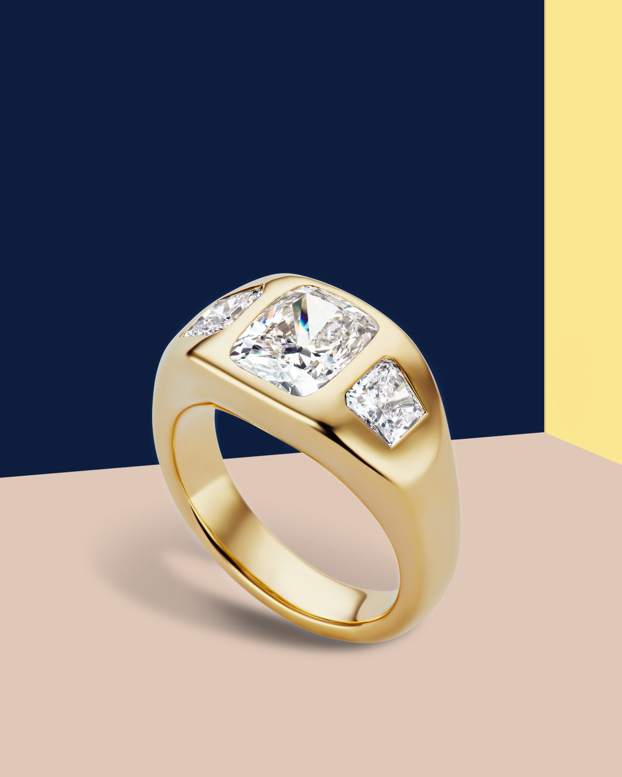 Gypsy set ring in yellow gold with one center Asscher cut diamond and two side emerald cut diamonds