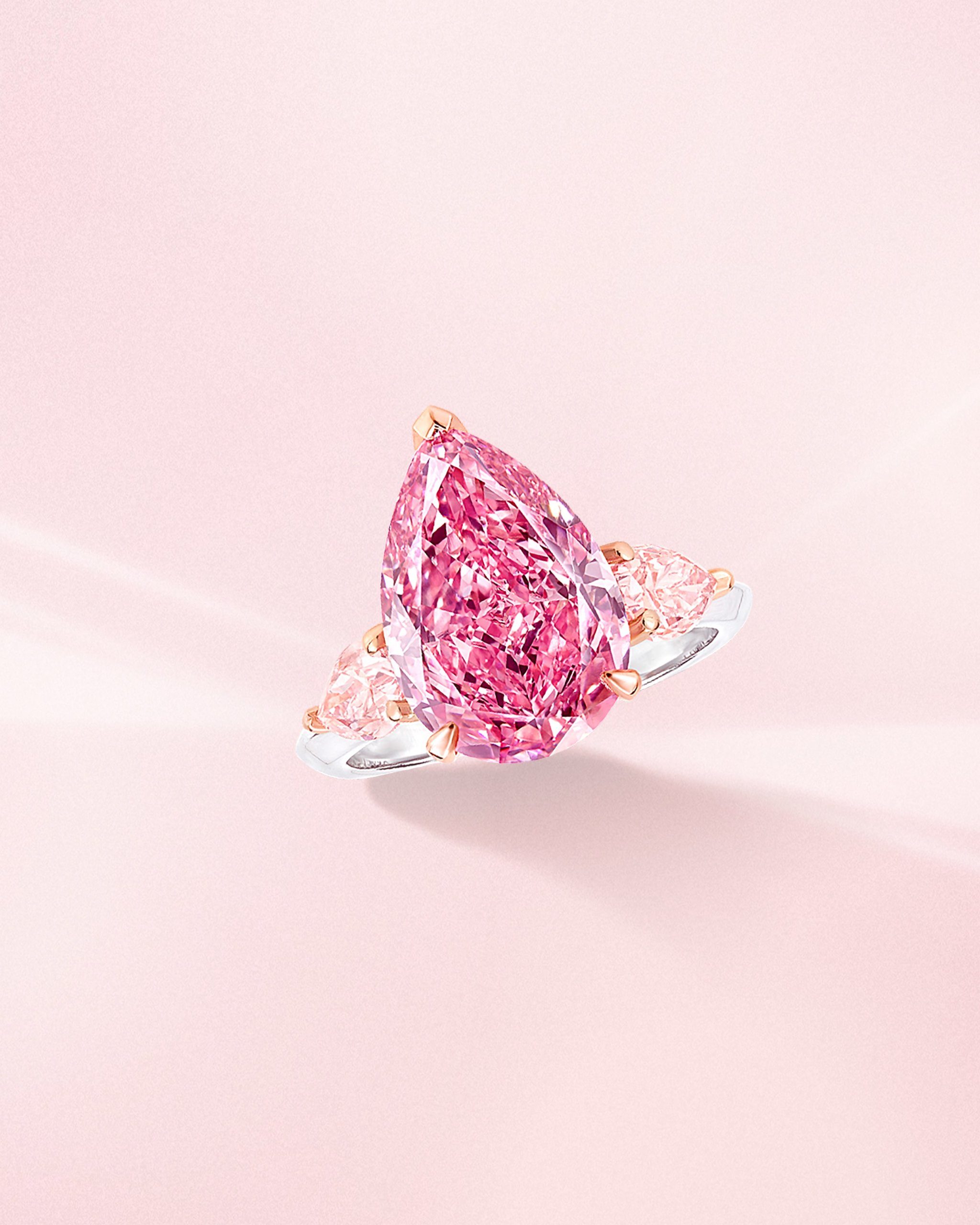 Fancy vivid pink pear shaped diamond ring with side light pink diamonds on a platinum band from Graff