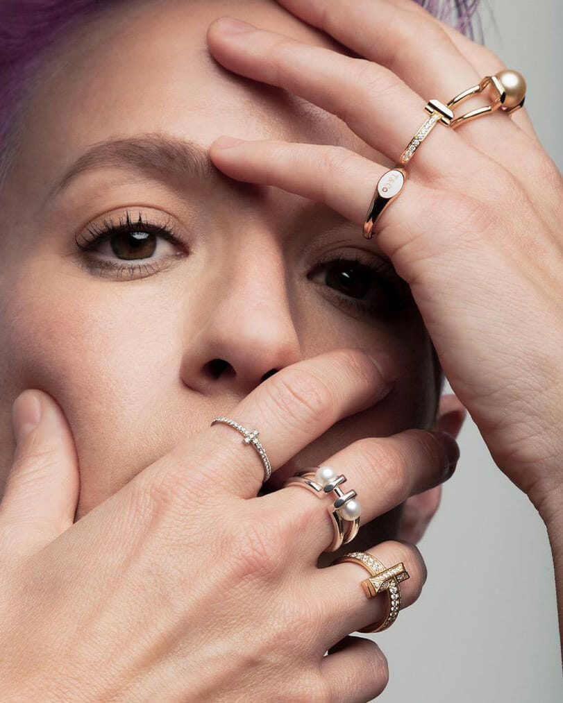 Soccer player Megan Rapinoe wearing, gold, diamond and pearl Tiffany & Co. rings.