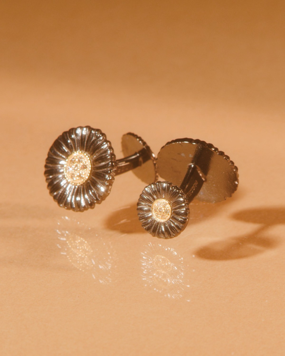 Buccellati blossoms cufflinks in ruthenium, gold and diamonds.