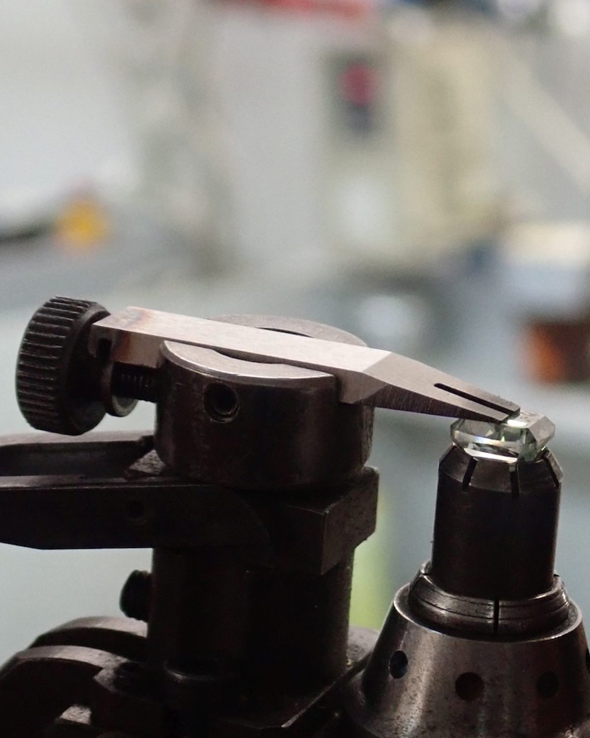Green diamond  in a dop, being examined 