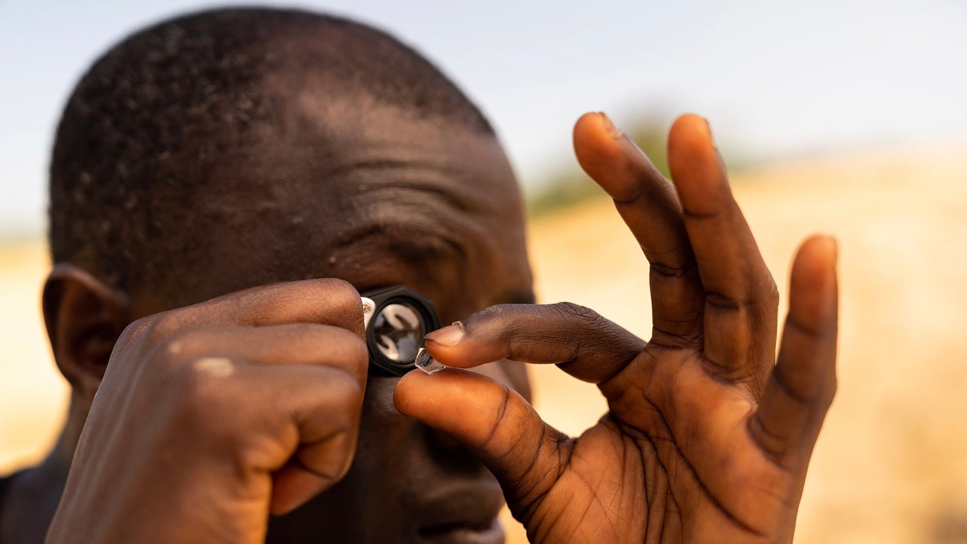 Miner viewing a diamond under a loupe prior to logging. (Courtesy of GemFair)
