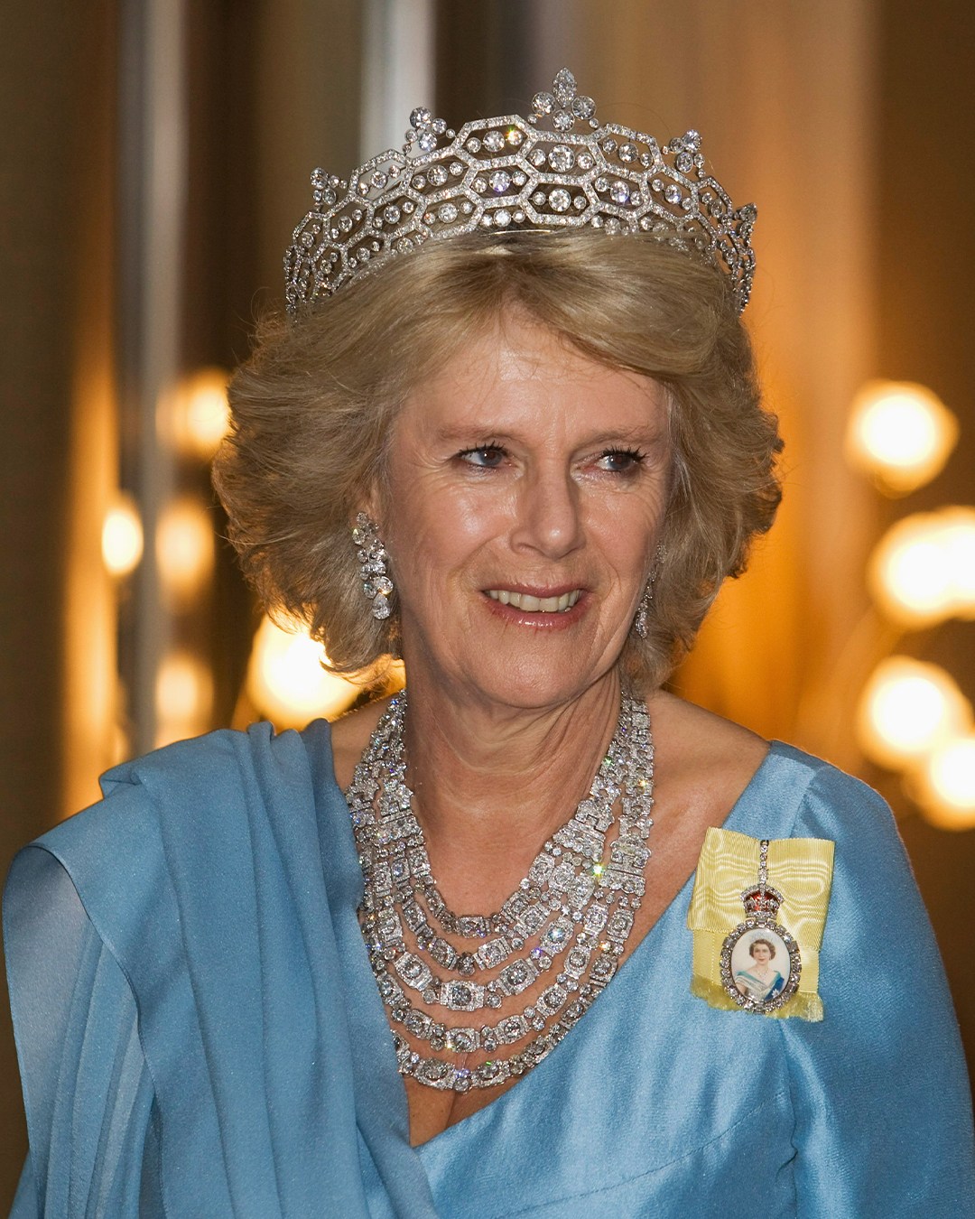 Queen Camilla wears the Greville Tiara and five-row diamond festoon necklace, paired with the Royal Family Order of Queen Elizabeth II.