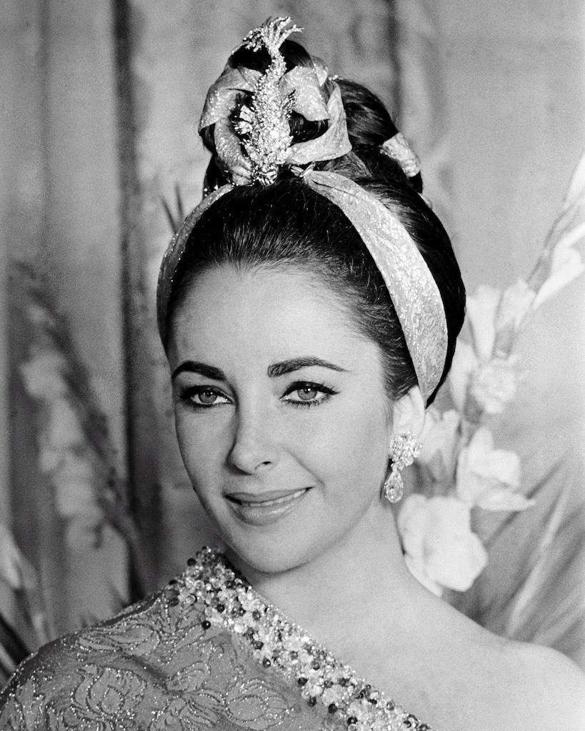 Elizabeth Taylor wore a diamond and gold brooch with sapphire eyes, "The Night of the Iguana" by Tiffany, designed by Jean Schlumberger, and Bulgari diamond and jonquil earrings. (Getty Images)