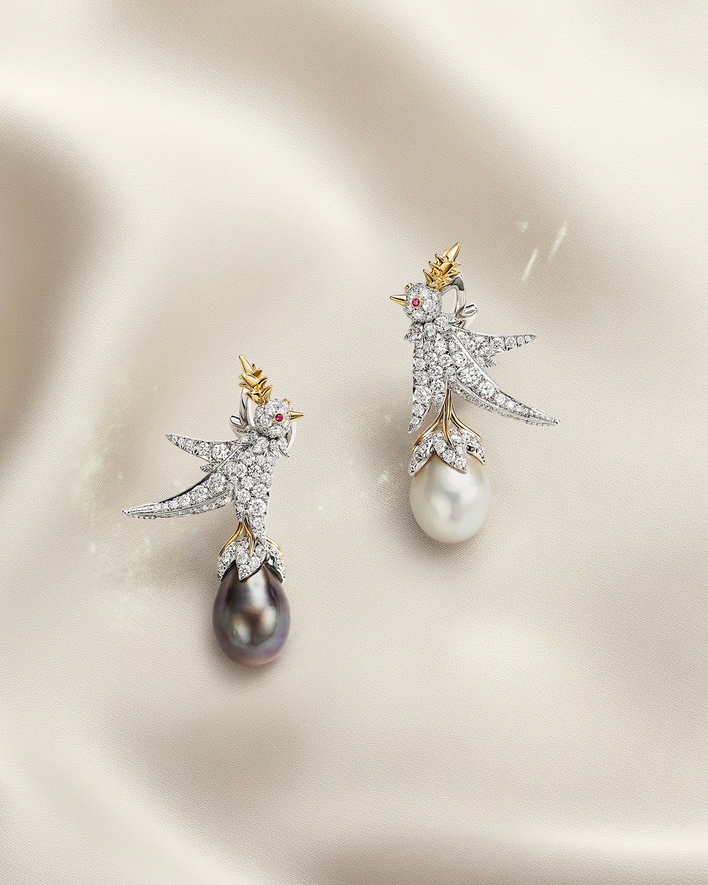 Bird on a Pearl earrings with a 9-carat light cream drop natural saltwater pearl, an 11-carat dark gray drop natural saltwater pearl, diamonds and rubies. (Courtesy of Tiffany & Co.)