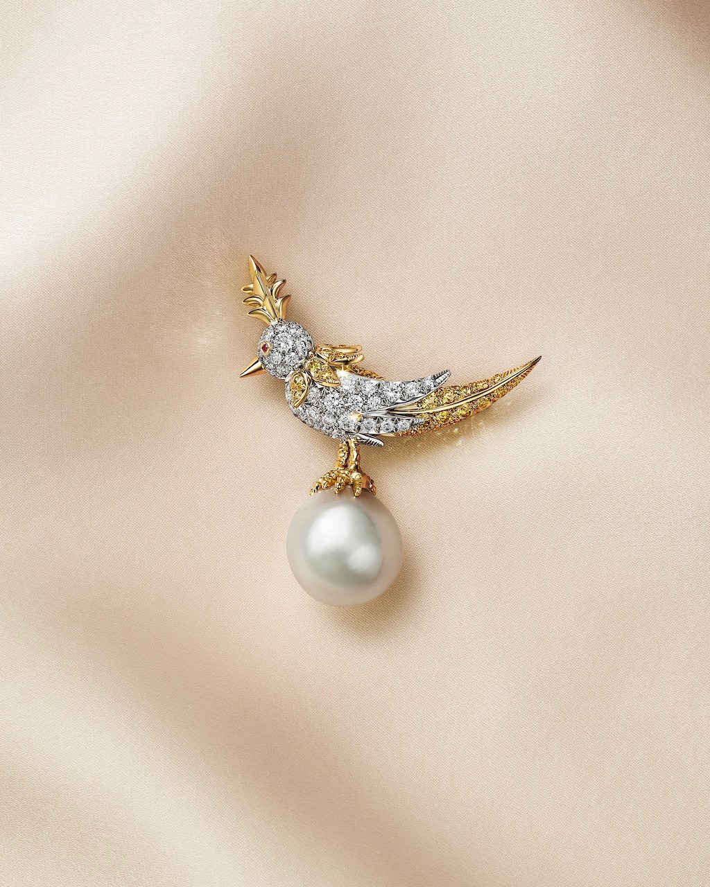 Bird on a Pearl brooch with a 24-carat white near-drop natural saltwater pearl, fancy yellow diamonds, white diamonds and rubies. (Courtesy of Tiffany & Co.)