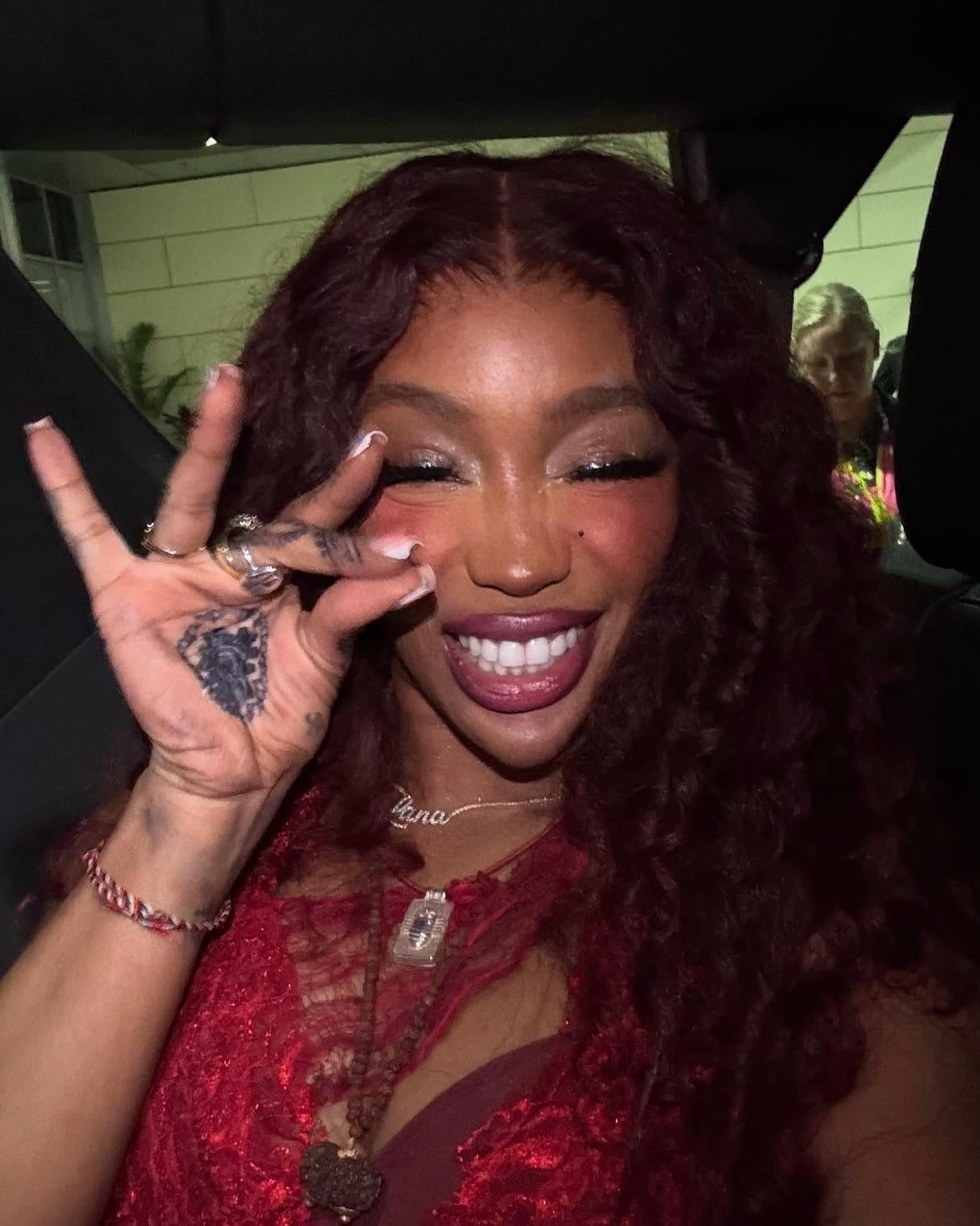 Sza wearing a diamond name necklace