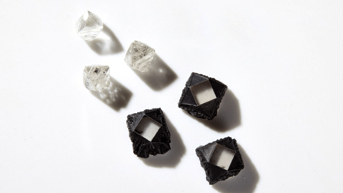 Rough natural diamonds alongside uncut lab grown stones