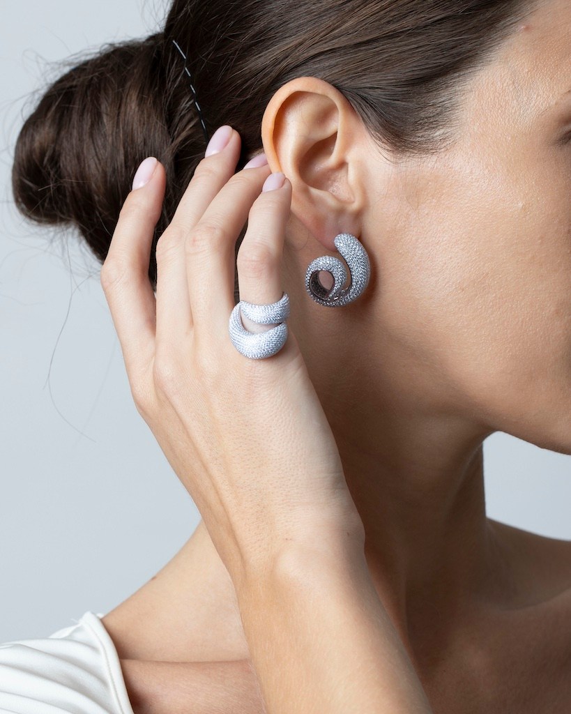 Model wearing pave diamonds earrings and ring.