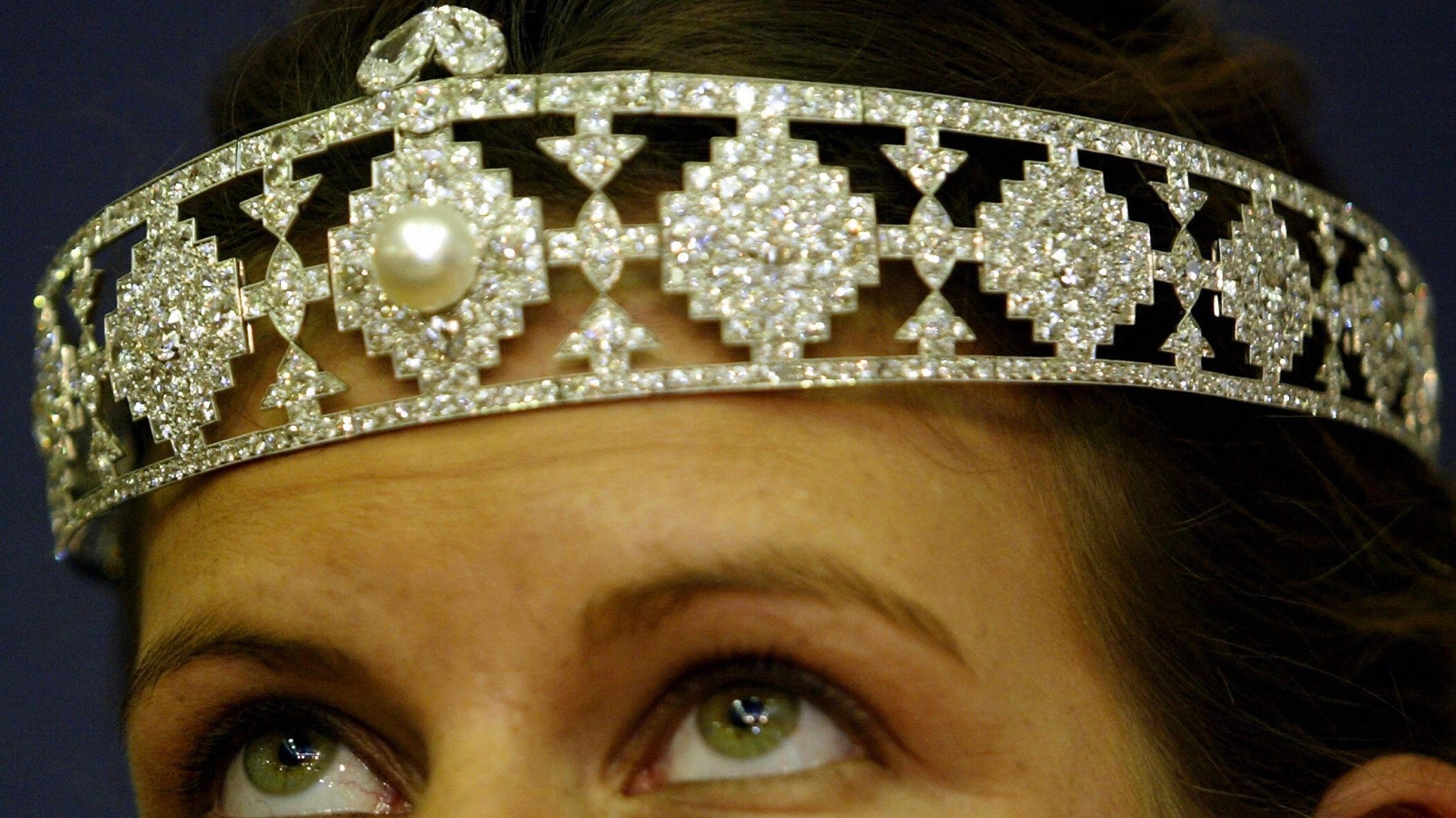 An assistant at Christie's auction house wears a diamond-encrusted platinum bandeau made by Cartier valued at 150-200,000 USD formerly owned by heiress Doris Duke 04 May, 2004. (ALESSANDRO ABBONIZIO/AFP via Getty Images)