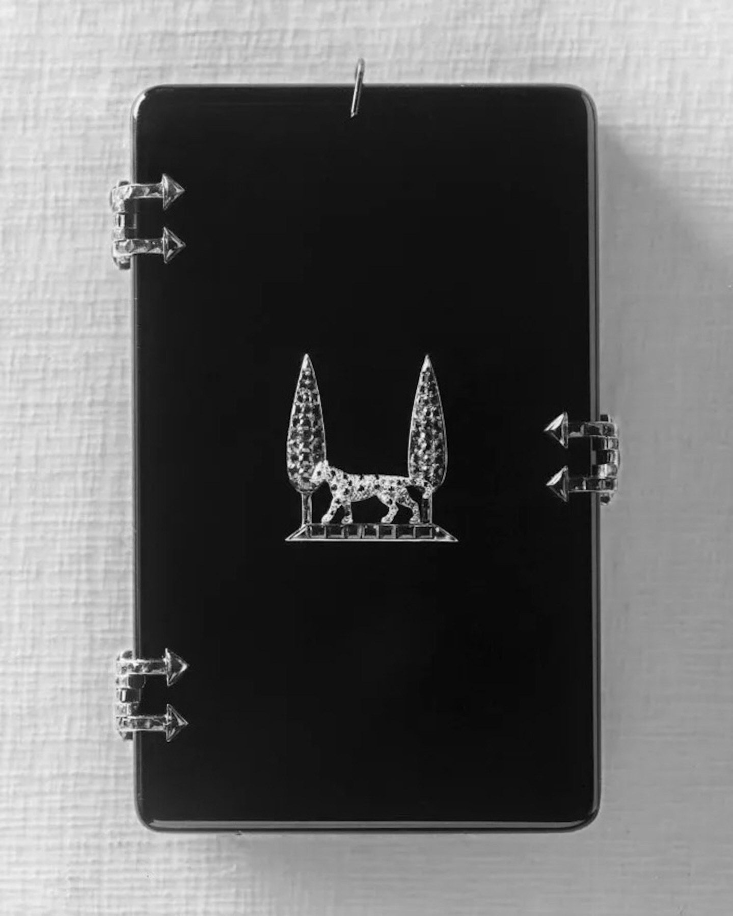 Cigarette case, Cartier Paris, 1917. A gift from Louis Cartier to Jeanne Toussaint. Produced in onyx, rubies, and emeralds with a panther appliqué in platinum, natural diamonds, and onyx, between two cypress trees in emeralds and rubies.