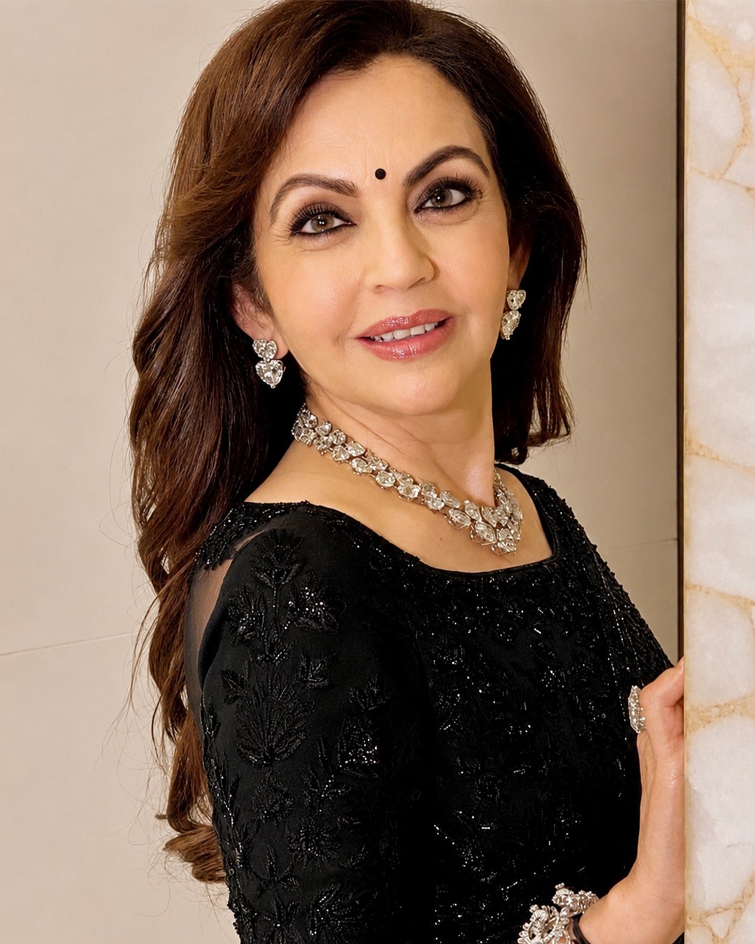 Isha and Nita Ambani wearing elegant diamond earrings and necklaces.