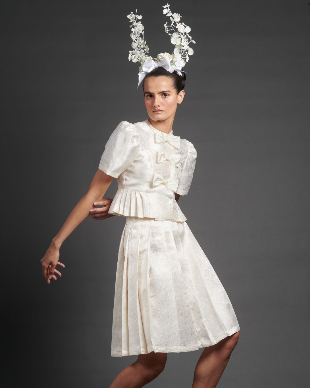 The bow jacket and pleated skirt