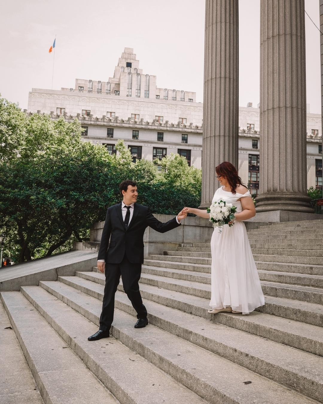 Couple in wedding attire on stairs Imperfect Engagement Rings